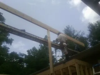 Carpenter setting a ridge beam over a new addition frame — Ice Dam Removal by Roofing Brothers in Haverhill