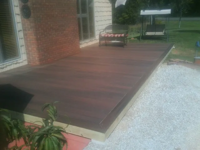 Freshly stained wood deck built against a brick home in Haverhill