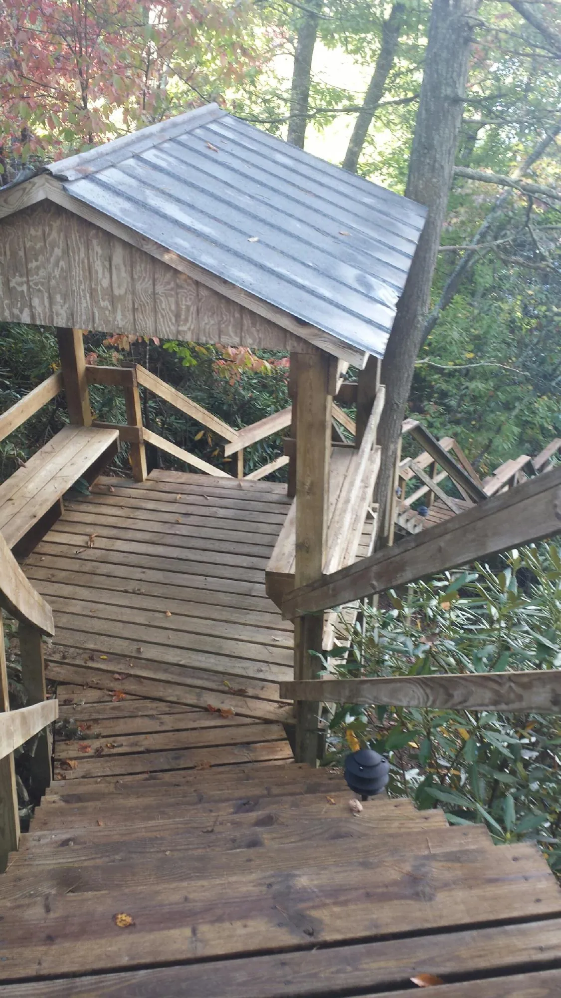 Metal roofed shelter over wooden steps on a wooded walkway — Skylight Repair & Installation work by our crew in Haverhill